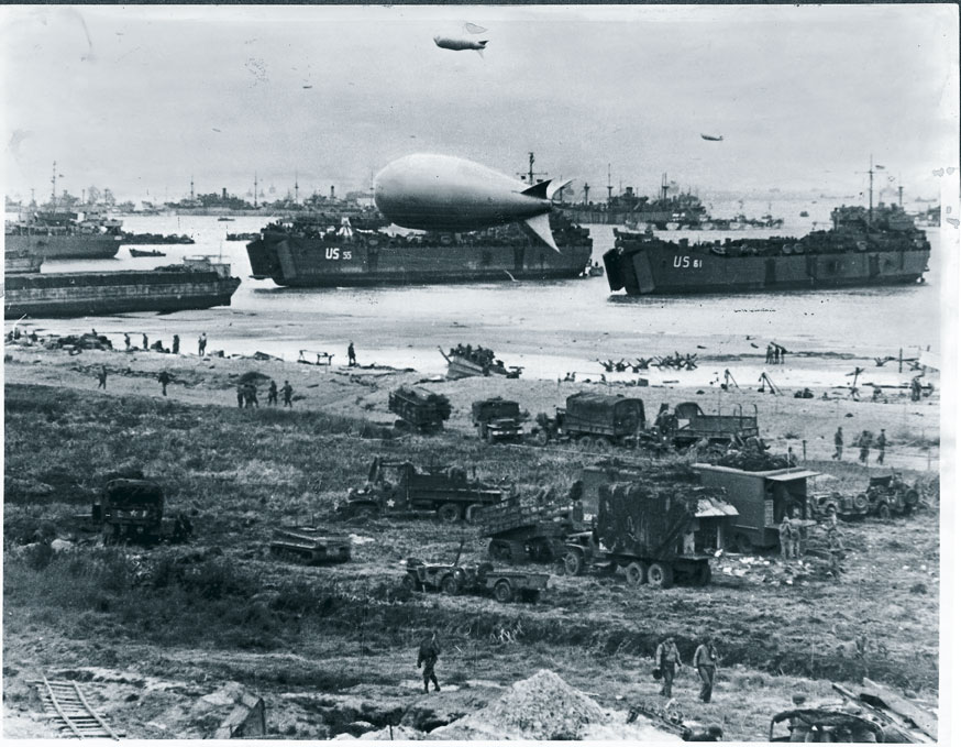 Mezzi militari statunitensi su una spiaggia della Normandia Le priorità degli Alleati nei giorni che seguirono lo sbarco furono di collegare le teste di ponte, prendere Caen e catturare il porto di Cherbourg per fornire una linea di approvvigionamento sicura.