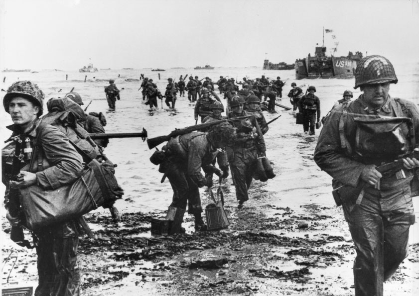 Soldati americani sulla costa della Normandia Soldati durante lo sbarco nel tratto di costa compreso fra la penisola di Cherbourg (Bassa Normandia) e Caen. I mezzi anfibi, scaricarono sulla spiaggia migliaia di uomini, costituendo una testa di ponte di 50 km.