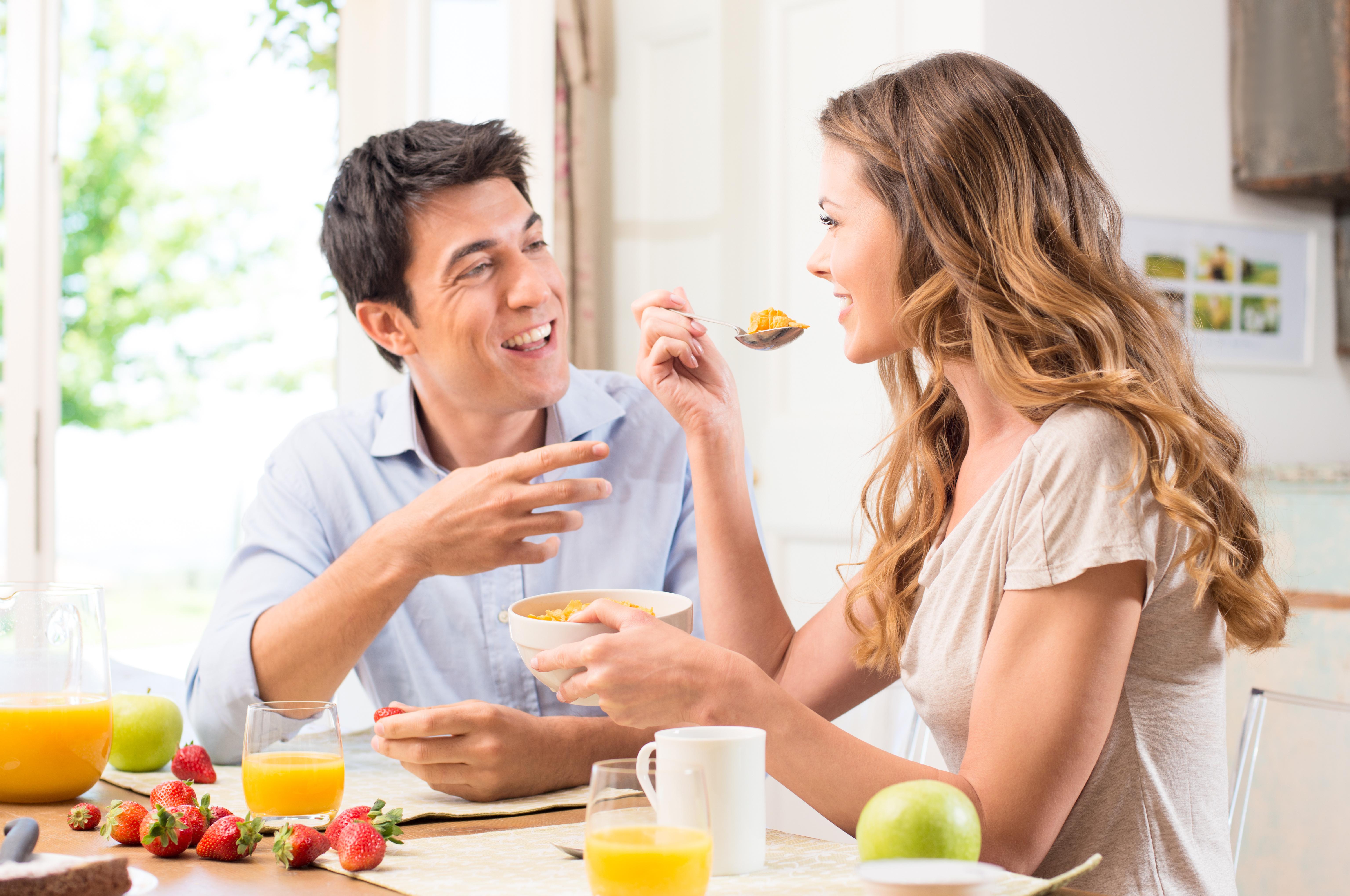 Обед влюбленных. Мужчина и женщина завтракают. Муж и жена завтракают. Мужчина и женщина завтрак. Мужчина завтракает на кухне.