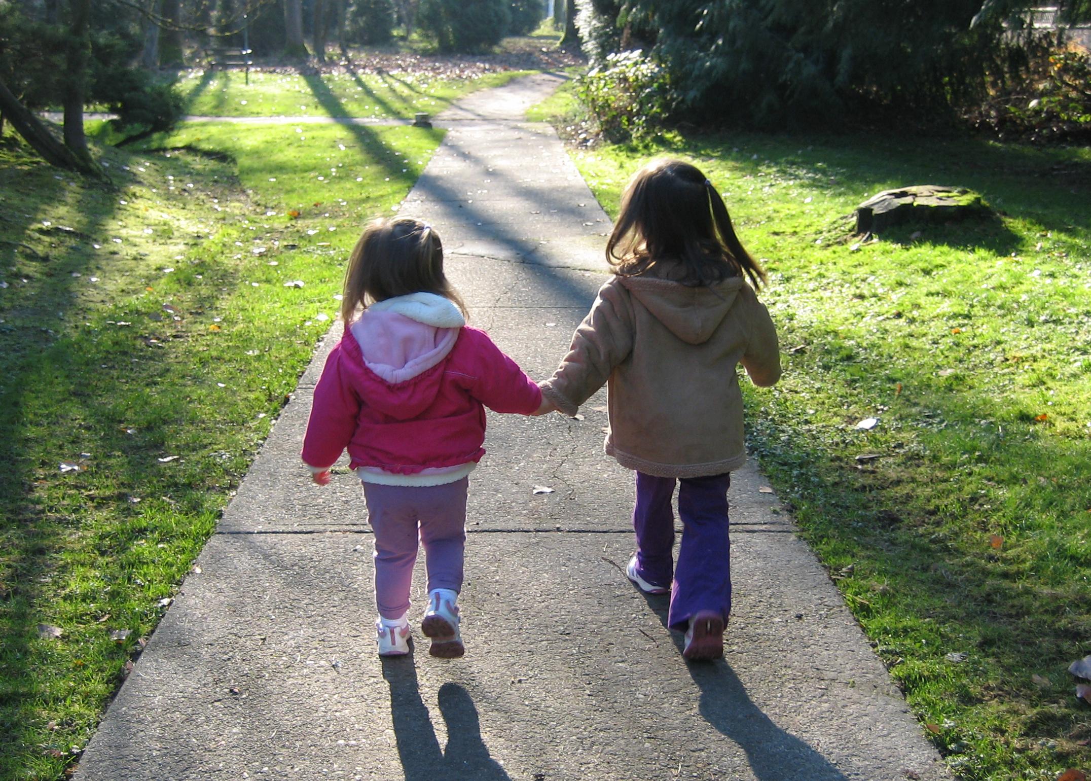 Гуляем крошки. Маленькие девочки гуляют. Две девочки идут. 2 Девочки идут в детский сад. Тротуар для детей.