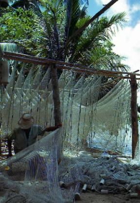 Polinesia Francese. Pescatore ripara le reti nell'isola di Moorea.De Agostini Picture Library/C. Rives