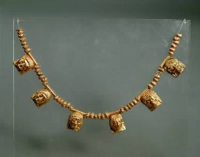 Puglia. Collana d'oro con pendagli di piccole maschere umane (Taranto, Museo Archeologico Nazionale).De Agostini Picture Library/G. Dagli Orti